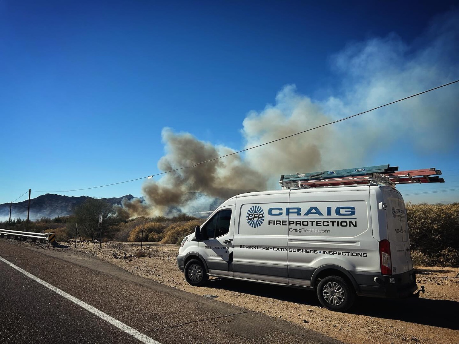 Craig Fire Protection van staged near a brush fire